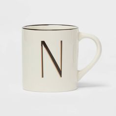 a white and black coffee mug with the letter n on it's front side