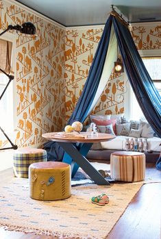 a living room filled with furniture and walls covered in animal wallpaper, including a canopy bed