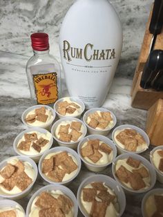 small cups filled with food next to a bottle of rumchata and a corkscrew