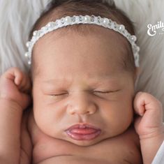 a newborn baby is wearing a headband