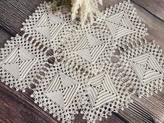 a white doily on a wooden table with flowers