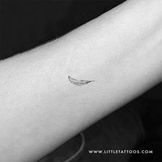 a small feather tattoo on the arm