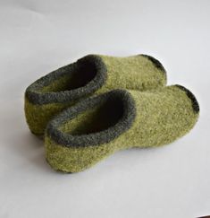 a pair of green slippers sitting on top of a white table