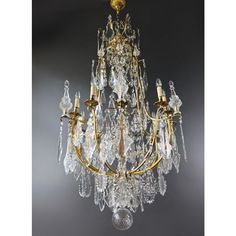 a chandelier hanging from the ceiling with many crystal drops on it's arms