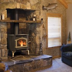 a living room with a couch and a fire place inside of it, in front of a stone wall