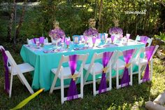 a table set up with purple and blue decorations