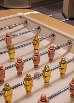 a foosball table with gold and red knobs