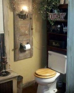 a bathroom with a wooden toilet seat next to a wall mounted mirror and potted plant