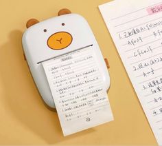 a close up of a paper dispenser near a piece of paper with writing on it