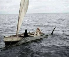 a man sitting in a small boat with a sail on it's front end