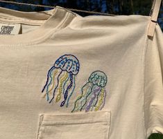 "This is a size medium unisex Comfort Colors t-shirt in color \"ivory\" (off-white/cream). Hand embroidered by yours truly! Green, blue, and purple jellyfish.  100% cotton, handwash or wash on delicate cycle; hang dry." Embroidery On Shirts, Embroidered Jellyfish, Purple Jellyfish, Ocean Outfits, Nautical Tattoo, Embroidery Tshirt, Fish Print, Yours Truly, Color Ivory