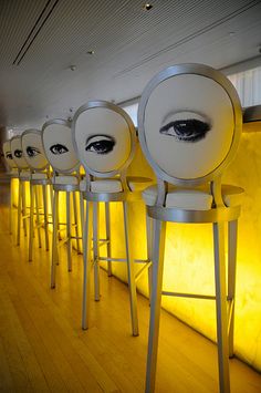 there are many chairs with eyeballs on them in the room that is lit up