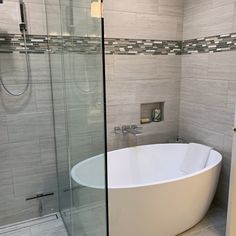 a white bath tub sitting inside of a bathroom next to a walk - in shower