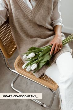 a woman sitting on a chair holding flowers