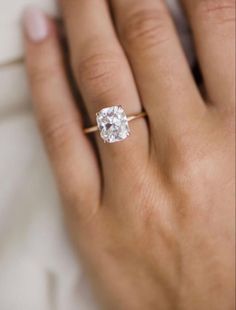 a woman's hand with a diamond ring on it