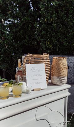 a table topped with drinks next to a basket