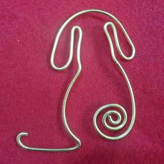 a metal wire sculpture on a red cloth with the shape of a woman's head