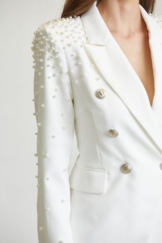 Luminous imitation-pearl beads dance along the shoulders of a white blazer tailored with structured shoulders and pretty matching pants. Sold Separately. Jacket - • Notched Lapel Collar• Double Breasted• Padded Shoulders• Pearl Embellished Shoulders• Sleeves Pants - • Hight Waisted • Flap Pockets All White Blazer Outfit, Wedding Blazer Women, Shoulder Embroidery Designs, Bedazzled Blazer, Blazer With Pearls, Pearls Outfit, Pearl Suit, Pearl Blazer, Shoulder Beads