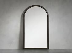 an arched mirror on top of a table