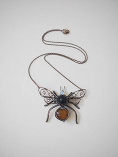 a necklace with a spider hanging from it's side