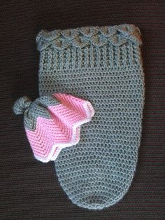 a crocheted mitt with a purple and white hat on it