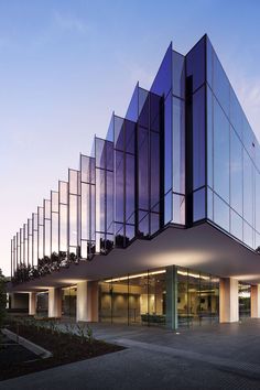 the building has many glass panels on it's sides and is lit up at night