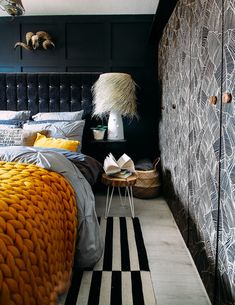 a bedroom with black walls and yellow bedding in the corner, an animal head hanging on the wall