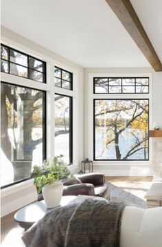 a living room filled with furniture and windows next to a fire place in front of a fireplace