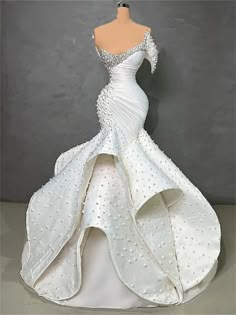 a white wedding dress with beading on it