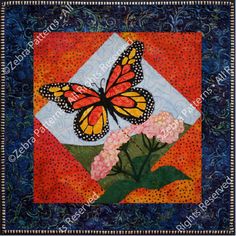 a quilt with a butterfly on it and pink flowers in the center, against an orange background