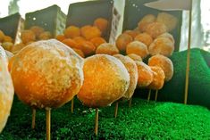 there are many desserts on sticks in the grass with oranges and green moss