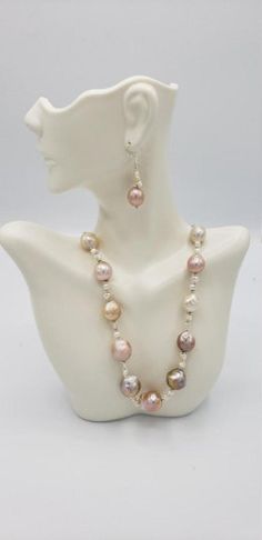 "Baroque pearls have a non-spherical shape that gives them a unique appearance. No two baroque pearl necklaces will ever be the same. The white to Pink and gold baroque pearl necklace choker is no exception, with a number of interestingly shaped pearls forming the 19-inch strand. The large baroque freshwater pearls have an AA quality luster and white body color. The baroque pearls are cultured in freshwater and have a thick nacre. The big baroque has a tone of white to pink and gold. This pearl Pearl White Baroque Pearl Beaded Necklace, Pearl White Baroque Pearl Beaded Necklace With Round Beads, Pearl White Baroque Pearl Beaded Necklaces, Silver Beaded Baroque Pearl Necklace, Teardrop Shaped Beaded Pearl Necklace, Elegant Teardrop Pearl Beaded Necklace, Baroque Single Strand Pearl Necklace, Baroque Pearl Beaded Necklace With Round Beads, Pearl White Oval Beads Pearl Necklace