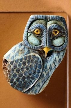 an owl figurine is hanging on the wall