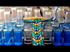 there is a toothbrush holder made out of plastic bottles and glass jars with blue liquid in them