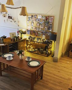 a living room filled with furniture and pictures on the wall next to a coffee table