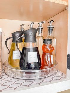 three different types of liquid in bottles on a glass shelf next to a bottle opener