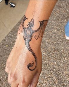 a hand with a dragon tattoo on it