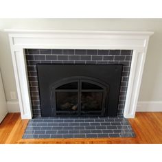 a fire place in a living room with wood flooring and white fireplace mantel