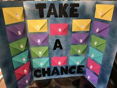 there is a sign that says take a chance with origami pieces on it