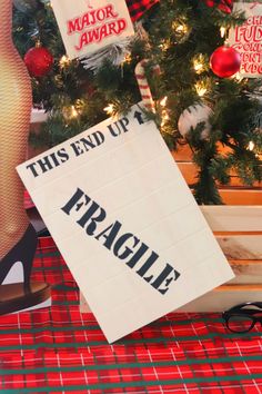 this end up fragile sign is next to a christmas tree with stockings on the ground