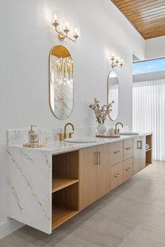 a large bathroom with two sinks and mirrors on the wall next to eachother