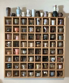 a wooden shelf filled with lots of cups