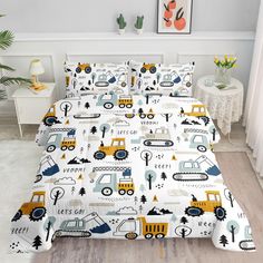 a bed with construction themed sheets and pillowcases on top of the bedspread