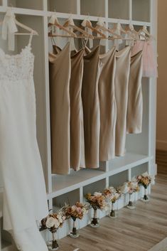 wedding gowns and flowers are hanging on the rack