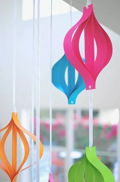 colorful paper ornaments hanging from strings in a room