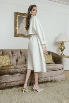 This cozy wool coat will keep you on trend all winter long. The Madeline coat features shoulder pads and a front tie belt to create an hour-glass shape.  The cropped,  flowy back and collared sleeves soften the look and make this coat perfect for a cold winter day. Chic Belted Beige Wool Coat, Chic Wool Coat With Belted Cuffs And Lapel Collar, Chic Belted Wool Coat, Chic Belted Wool Coat For Winter, Chic Winter Outerwear With Belted Cuffs, Elegant Cream Outerwear With Belted Cuffs, Fall Wool Coat With Belted Cuffs, Chic Spring Wool Coat With Belt, Long Sleeve Wool Coat With Belted Cuffs