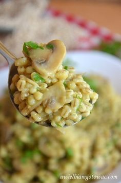 a spoon full of macaroni and cheese with a heart shaped mushroom on top