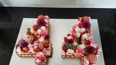 two cakes made to look like letters with flowers on them