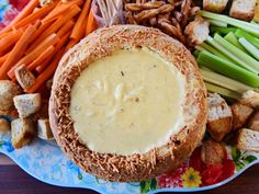 a plate with bread, carrots, celery and crackers on it