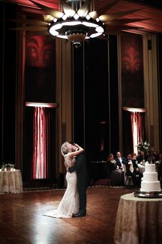 a bride and groom share their first dance at their wedding reception in the grand ballroom